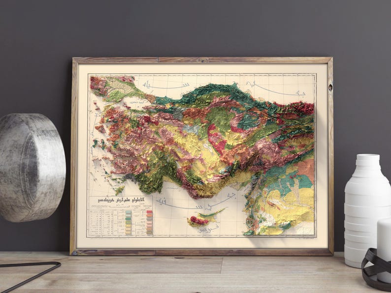 May include: A vintage, framed map of Turkey with a 3D relief effect. The map is printed in various shades of green, brown, yellow, and red, depicting the country's topography. The map includes a legend and a title in Turkish.