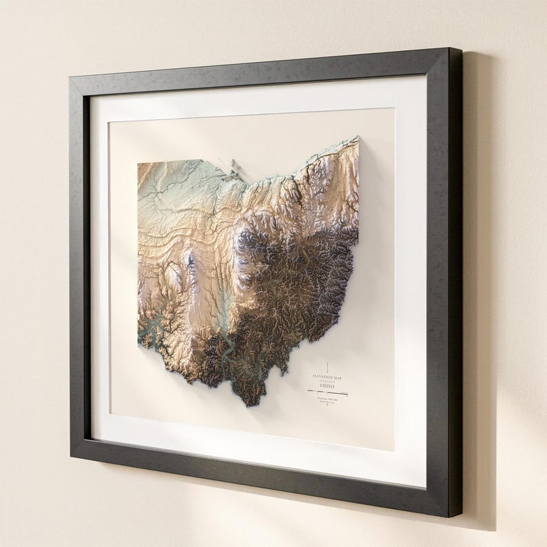 K&ouml;nnte beinhalten: Gerahmte 3D-Topografische Karte von Ohio, mit detaillierter Reliefdarstellung in Braun-, Beige- und Gr&uuml;nt&ouml;nen. Die Karte befindet sich vor einem cremefarbenen Hintergrund, gerahmt in einem schwarzen, rechteckigen Rahmen mit wei&szlig;em Passepartout.