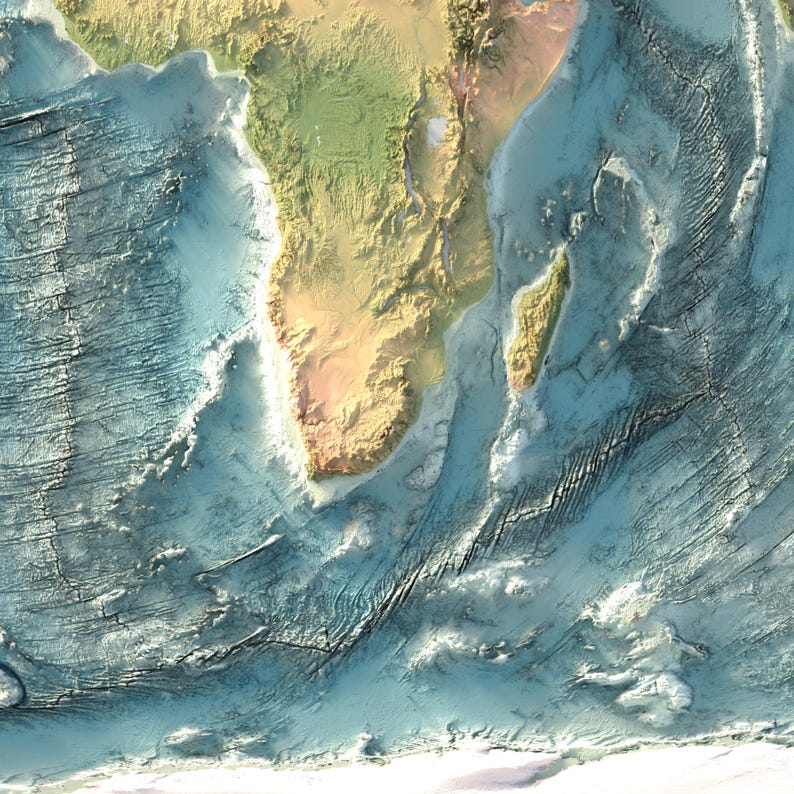 May include: A topographic map showing the southern tip of Africa and the island of Madagascar, featuring detailed relief shading of the landmasses and the complex, textured bathymetry of the surrounding Indian and Atlantic Ocean seafloor.