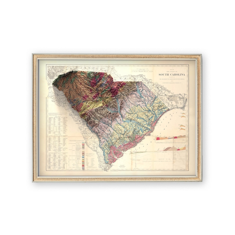 Pode incluir: Um mapa vintage da Carolina do Sul, mostrando a topografia e as caracter&iacute;sticas geol&oacute;gicas do estado. O mapa &eacute; impresso em uma variedade de cores, incluindo marrom, verde, azul e vermelho. O mapa &eacute; emoldurado em uma moldura de madeira clara.