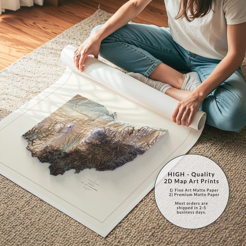 K&ouml;nnte beinhalten: Detaillierter 2D-Kartenkunstdruck, der eine Region mit Braunt&ouml;nen, Beige und Blau zur H&ouml;henangabe darstellt. Der Druck befindet sich auf mattem Papier, das auf einem neutralen Teppich ausgerollt ist. Die Karte ist wahrscheinlich ein Landkreis oder ein Bundesstaat.