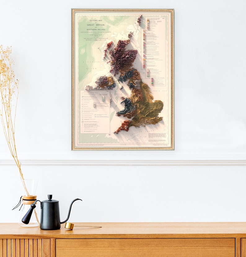 May include: A vintage-style, framed map of Great Britain and Northern Ireland. The map is a relief map, showing the topography of the islands in a 3D style. The map is printed in shades of brown, green, and red, with a key to the different geological formations.