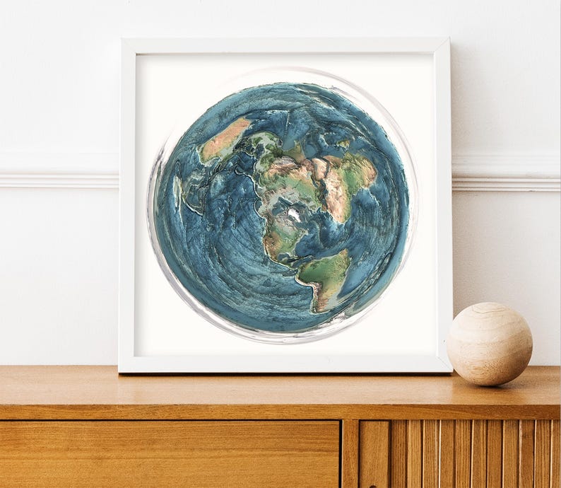 May include: A framed print of a detailed, three-dimensional rendering of Earth. The artwork features a blue and green color palette, showcasing continents and oceans. The print is displayed in a white frame, with a wooden sphere on the right.