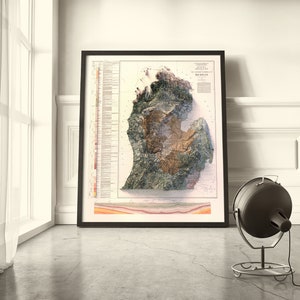 Puede incluir: Un mapa enmarcado de Michigan con un dise&ntilde;o de relieve topogr&aacute;fico 3D. El mapa est&aacute; en un marco negro y tiene un fondo blanco. El mapa est&aacute; rodeado por una pared blanca y un suelo negro.