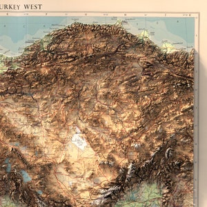 May include: A detailed topographic map of western Turkey, showing the country's diverse landscape, including mountains, valleys, and rivers. The map is printed in brown, green, and blue tones, with labels for major cities and geographic features.