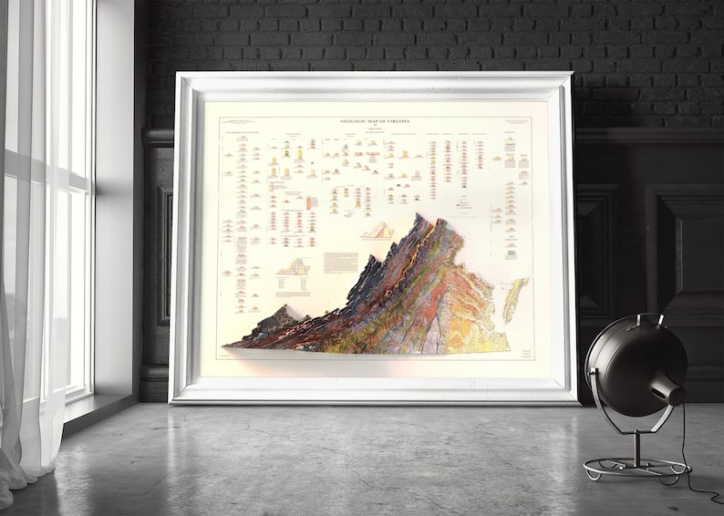 May include: A vintage geological map of Virginia, showing the state's geological formations in a colorful, 3D relief style. The map is framed in a white frame and is displayed on a gray floor.