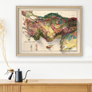 May include: A vintage, detailed relief map of the Anatolian Peninsula, also known as Asia Minor, with a colour-coded key showing elevation and terrain. The map is framed in a light brown frame and has a white background.