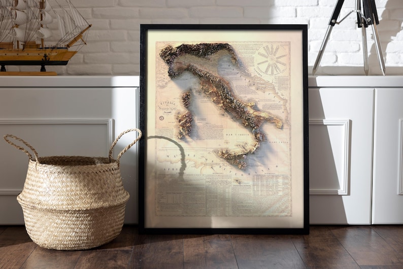 May include: A vintage-style map of Italy with a 3D textured design. The map is framed in black and has a white background with brown text and details. The map shows the outline of Italy with the islands of Sicily and Sardinia.