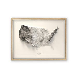 Pu&ograve; includere: Una mappa topografica 3D incorniciata degli Stati Uniti, con sfondo bianco e cornice beige. La mappa mostra l'altitudine del terreno in tonalit&agrave; di grigio.