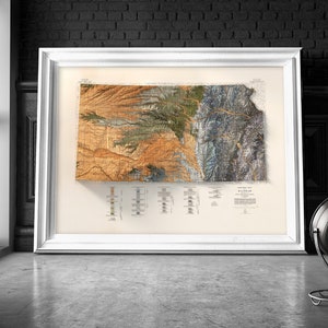 Puede incluir: Un mapa topogr&aacute;fico enmarcado de Wyoming, que muestra la elevaci&oacute;n y el terreno del estado en detalle. El mapa est&aacute; impreso en papel color crema con un estilo vintage.