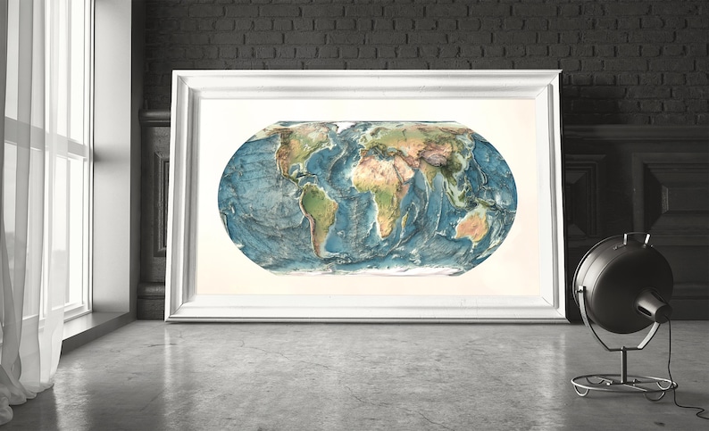 May include: A rectangular white frame containing a horizontal oval-shaped world map. The map features detailed topographical relief with blue oceans and multi-colored landmasses, set against a plain off-white background within the frame.