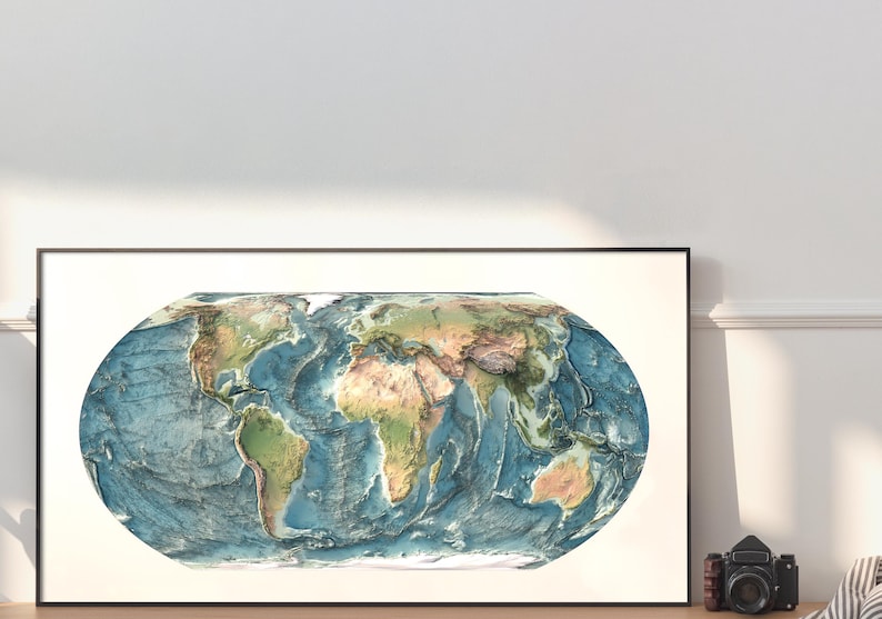 May include: A rectangular framed wall art print featuring an oval-shaped physical map of the world. The map displays continents in shades of green and brown, contrasted against deep blue ocean depths with visible topographical relief shading.