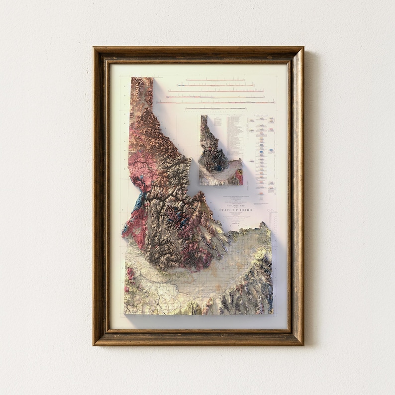 May include: Framed 3D relief map of Idaho, featuring detailed topographical features in shades of brown, pink, and green. The map is encased in a gold-toned wooden frame, showcasing the state's landscape with precision and artistic flair.