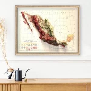 May include: A vintage map of Mexico with a relief-style depiction of the terrain. The map is framed in a light brown frame and has a color key showing different elevations. The title of the map is "REPUBLICA MEXICANA".