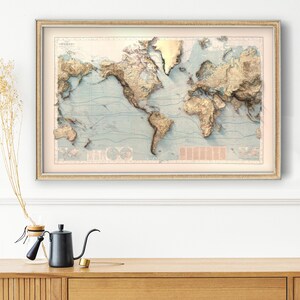 May include: A framed world map print featuring a raised relief style with golden-toned mountain ranges and landmasses set against a pale blue ocean background. The map includes detailed topographical shading, thin blue latitude lines, and text.