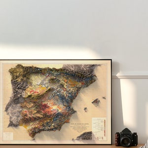 Puede incluir: Un mapa vintage enmarcado de Espa&ntilde;a con un relieve topogr&aacute;fico detallado que muestra el terreno variado del pa&iacute;s. El mapa est&aacute; impreso en tonos apagados de marr&oacute;n, verde, azul y amarillo, con una leyenda y una escala en la parte inferior.