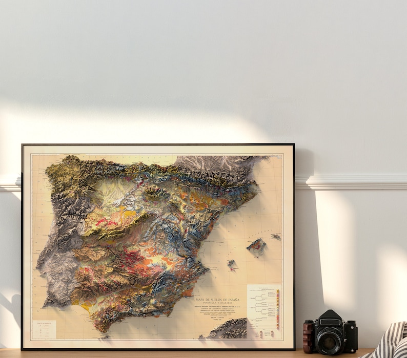 Puede incluir: Un mapa vintage enmarcado de Espa&ntilde;a con un relieve topogr&aacute;fico detallado que muestra el terreno variado del pa&iacute;s. El mapa est&aacute; impreso en tonos apagados de marr&oacute;n, verde, azul y amarillo, con una leyenda y una escala en la parte inferior.