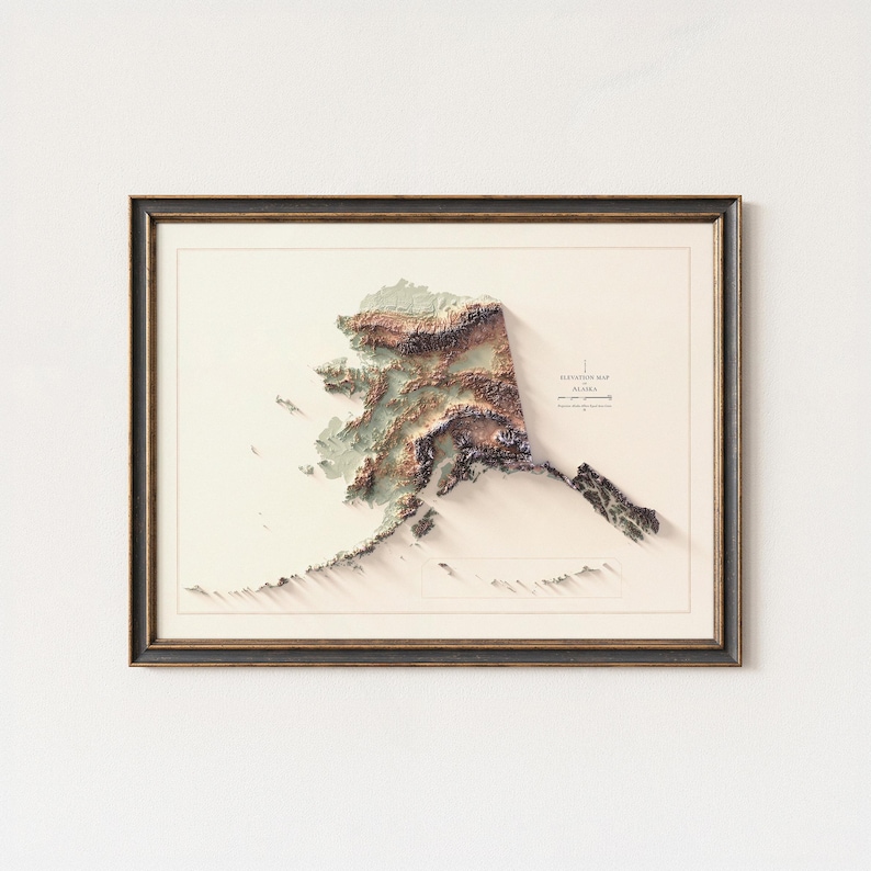 May include: Framed 3D elevation map of Alaska, featuring detailed topographical relief in shades of brown, green, and beige. The map is set against a cream background and enclosed in a dark brown frame, creating a striking visual representation.