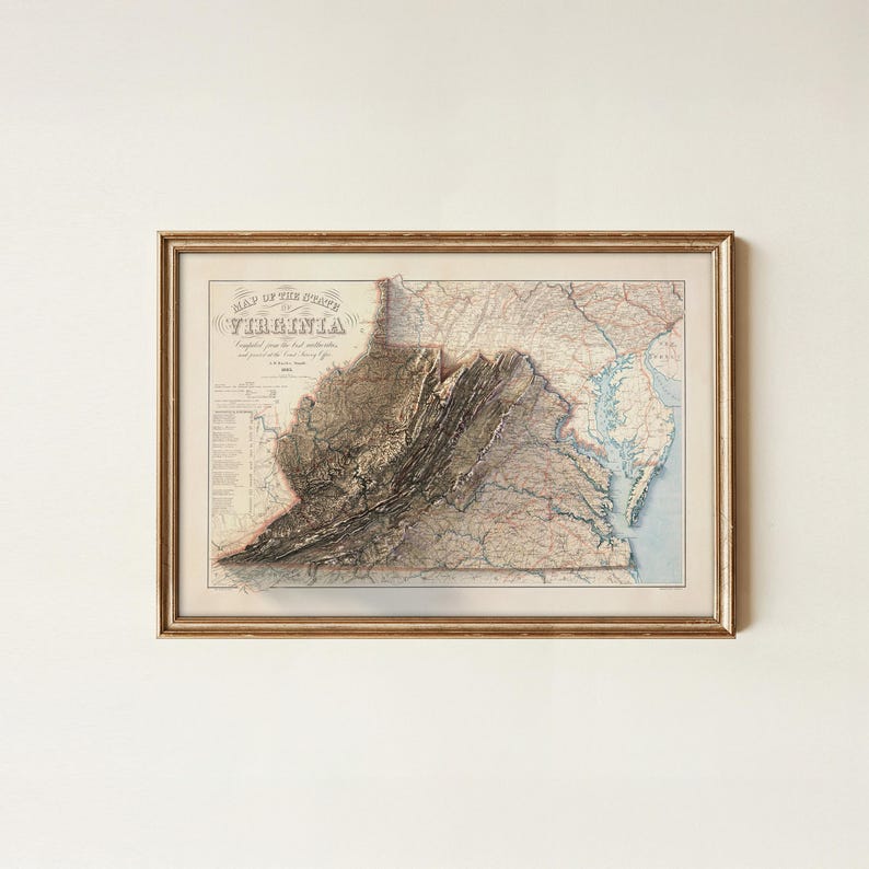 May include: Framed vintage map of Virginia, featuring detailed topographical information and the title "Map of the State of Virginia." The map is in a gold-colored frame, showcasing a detailed depiction of the state's landscape.
