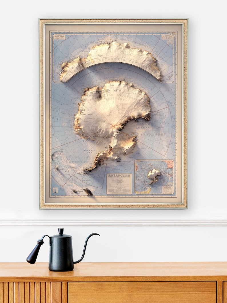 May include: A framed vintage map of Antarctica with a 3D relief effect. The map is in shades of blue, brown, and white, and features the continent's coastline, mountains, and glaciers. The map is titled "ANTARCTICA" and includes a compass rose and a scale bar.