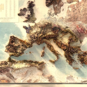 Pu&ograve; includere: Una mappa in rilievo dettagliata dell'Europa con un focus sul Mar Mediterraneo. La mappa presenta uno stile vintage con uno sfondo blu chiaro e colori marroni, beige e verdi per rappresentare il terreno.