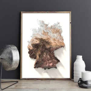 May include: A framed print of a 3D topographic map of Germany. The map is in shades of brown, beige, and white, with a shadow effect. The word "GERMANY" is printed at the bottom of the map.