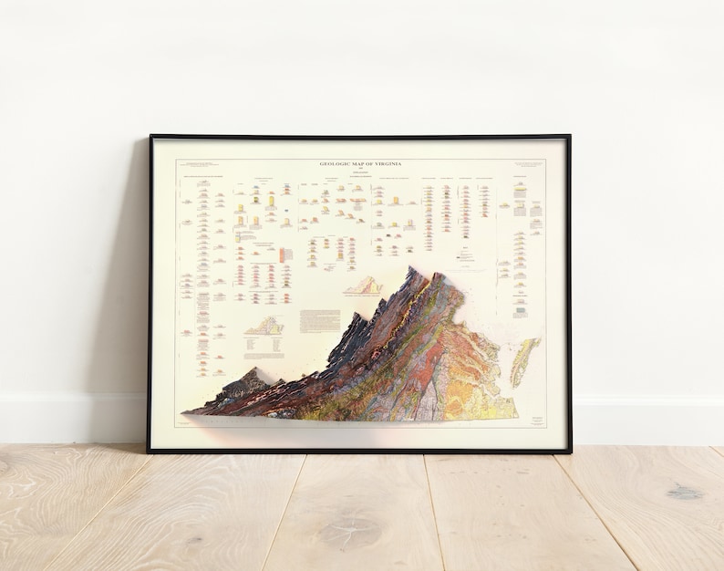 May include: A geological map of Virginia, showing the different rock formations and their ages. The map is in a black frame and is hanging on a white wall.