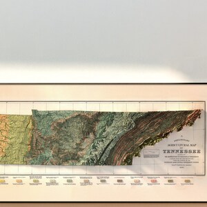 May include: A framed vintage map of Tennessee with a relief map style showing the state's topography. The map is in a black frame and has a light peach background. The map is titled "A Preliminary Agricultural Map of Tennessee".