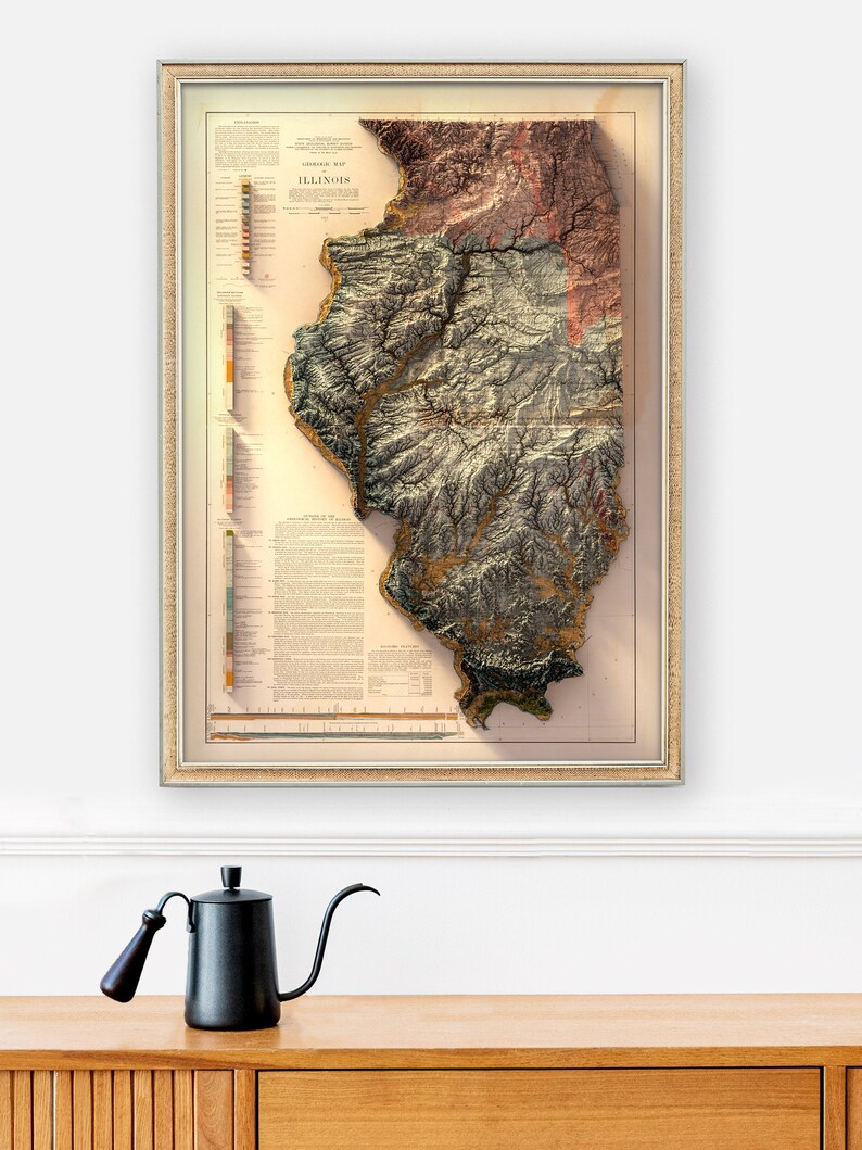 May include: A vintage framed map of Illinois with a 3D relief design. The map is in shades of brown, green, and red, with a key to the different elevations. The map is titled "Geological Map of Illinois".