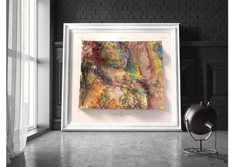 Puede incluir: Un mapa topogr&aacute;fico enmarcado de Wyoming, que muestra el terreno diverso del estado en tonos de marr&oacute;n, verde, azul y amarillo. El mapa est&aacute; titulado "Topographic Map of Wyoming" e incluye un aviso de copyright.