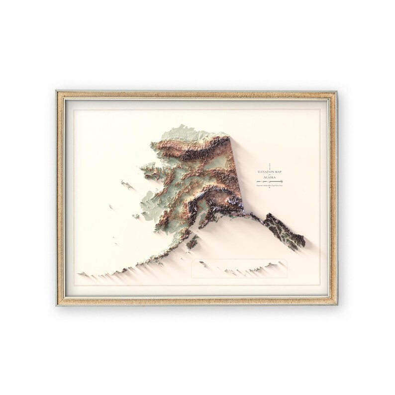 May include: Framed elevation map of Alaska, featuring a 3D topographic representation of the state. The map showcases varying shades of brown, green, and white, with the text "Elevation Map Alaska" in the upper right corner. The frame is a light gold color.