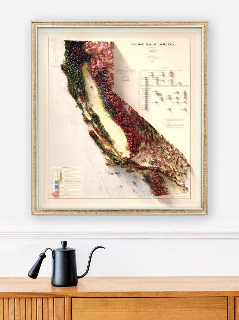 May include: A framed vintage geologic map of California, with a 3D relief effect. The map shows a detailed, colour-coded representation of the state's geological features, framed in a gold-coloured frame. The text "GEOLOGIC MAP OF CALIFORNIA" is visible.