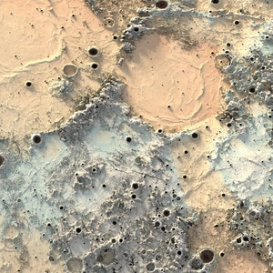 May include: A close-up of a textured surface with a variety of craters and holes. The surface is a mix of light brown, beige, and gray colors.