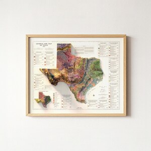 Op de afbeelding: Een ingelijste kaart van Texas, die de bodemsamenstelling weergeeft met een 3D-reli&euml;feffect. De kaart gebruikt verschillende kleuren om verschillende bodemtypen weer te geven. De lijst is van licht hout en de kaart bevat de tekst "GENERAL SOIL MAP OF TEXAS".