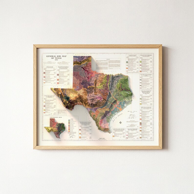 Op de afbeelding: Een ingelijste kaart van Texas, die de bodemsamenstelling weergeeft met een 3D-reli&euml;feffect. De kaart gebruikt verschillende kleuren om verschillende bodemtypen weer te geven. De lijst is van licht hout en de kaart bevat de tekst "GENERAL SOIL MAP OF TEXAS".