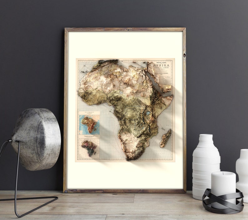 May include: A framed vintage map of Africa with a 3D embossed effect. The map is printed on cream paper with brown and green colors. The title of the map is "AFRIKA" in a vintage font.