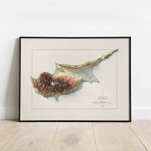 May include: A framed topographic map of Cyprus, showing the island's terrain in shades of green, brown, and beige. The map is titled "Cyprus" and includes a scale bar and compass rose.