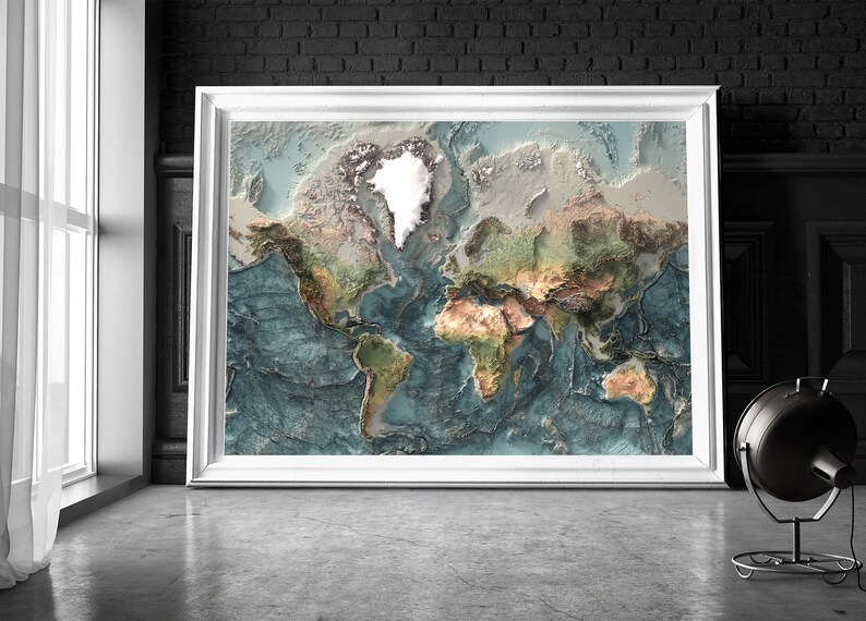 May include: A framed world map with a 3D effect, showing the continents in various shades of green, brown, and beige, with the oceans in shades of blue. The map is framed in white and is hanging on a brick wall.