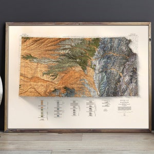 Puede incluir: Un mapa topogr&aacute;fico vintage del estado de Kansas, impreso en colores marr&oacute;n, verde y azul. El mapa est&aacute; enmarcado en un marco de madera y est&aacute; colgado en una pared.