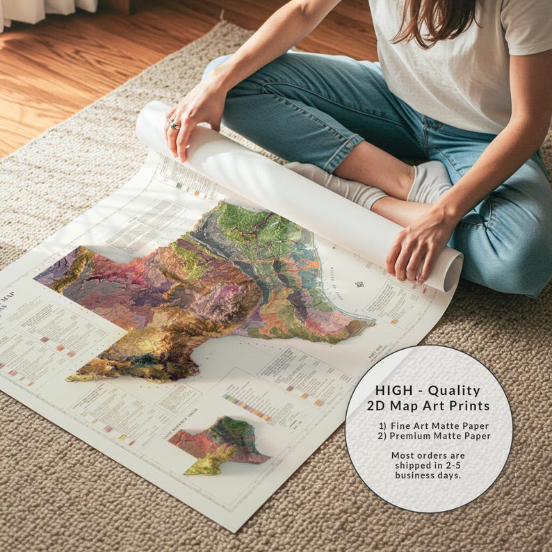 Op de afbeelding: Een persoon zit op een kleed en rolt een grote kaartkunstprint uit. De kaart heeft een 3D topografisch ontwerp met verschillende kleuren. De print bevat de tekst "HIGH - Quality 2D Map Art Prints". De kaart is gedrukt op mat papier.