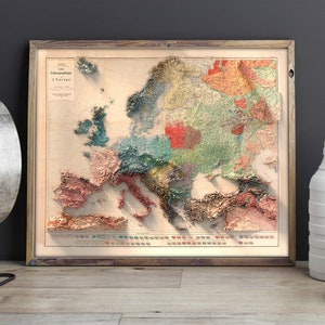 Op de afbeelding: Een vintage-stijl kaart van Europa met een 3D-effect, die verschillende regio's in verschillende kleuren laat zien. De kaart is ingelijst in een houten lijst en heeft een titel in het Frans: "Carte Oro-Hydrographique de L'Europe".
