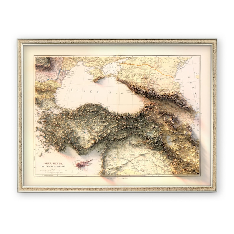 May include: A vintage map of Asia Minor, also known as Anatolia, with a 3D embossed effect. The map shows the Black Sea, the Mediterranean Sea, and the surrounding landmasses. The map is framed in a light brown frame.