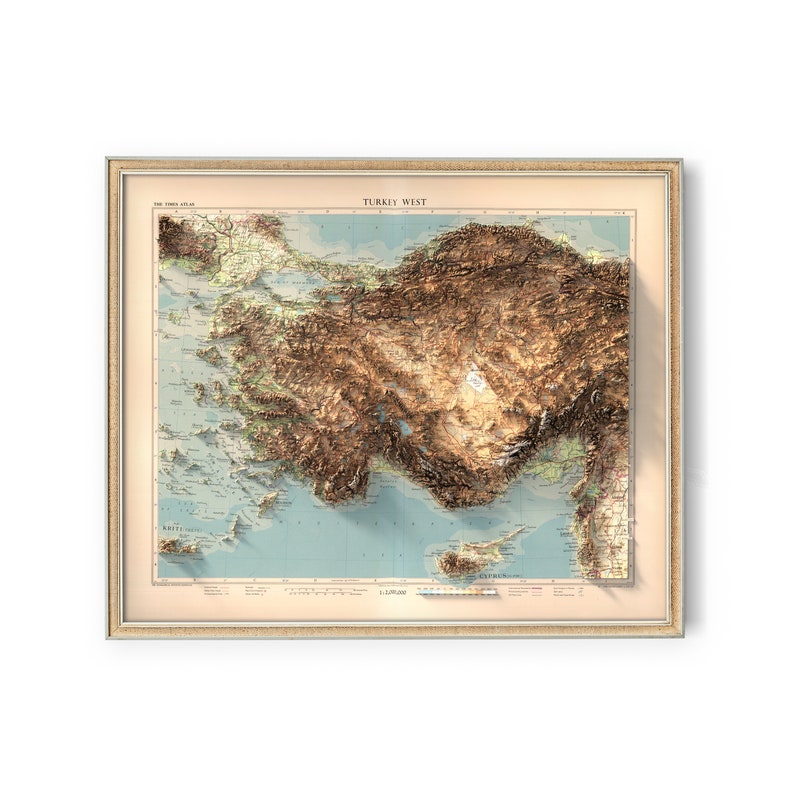 May include: A vintage, framed map of Turkey West, showing the topography of the region in a 3D style. The map is printed on paper with a light blue background and brown and beige colors to represent the terrain. The map is framed in a light brown frame with a gold trim.