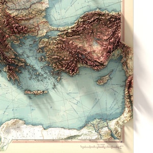 May include: A vintage map of the Mediterranean Sea with a 3D effect, showing the topography of the surrounding landmasses. The map is printed on a light blue background with brown lines and text.