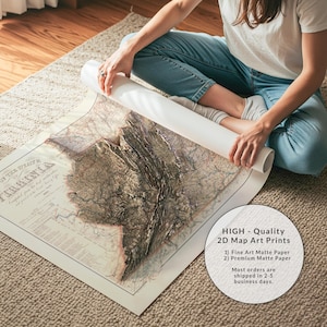 May include: A detailed map art print of Virginia, with a 3D relief effect. The map is printed on matte paper and is being unrolled. The image includes text that says "HIGH - Quality 2D Map Art Prints".