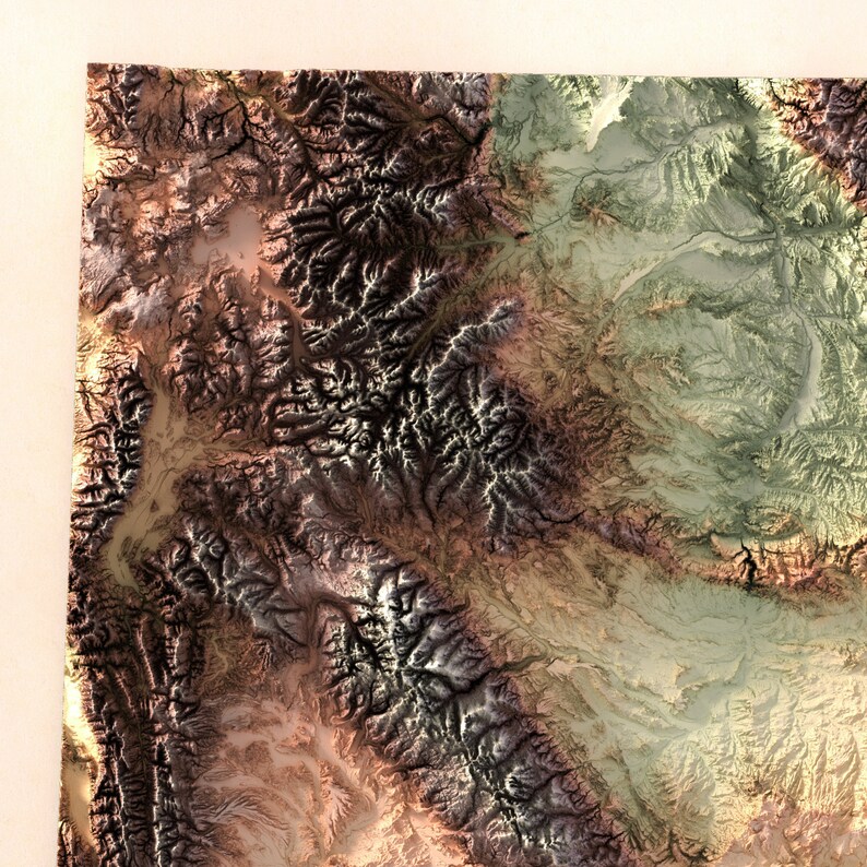 May include: A detailed aerial view of a mountainous region with a variety of colors and textures. The mountains are a mix of brown, green, and gray, with some areas of white snow. The image shows the natural beauty of the landscape.