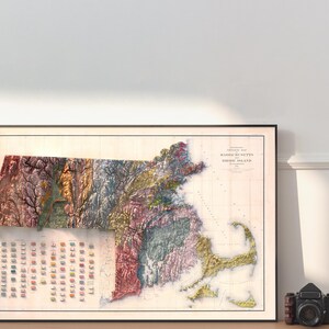 May include: A vintage map of Massachusetts and Rhode Island, showing the terrain in different colors. The map is framed in black and has a white background.