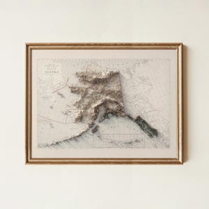 May include: Framed 3D relief map of Alaska, showcasing the state's topography in shades of brown and white. The map is set against a vintage-style background with geographical details and is encased in a gold-colored frame.
