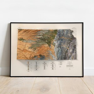 Puede incluir: Un mapa vintage del estado de Kansas, impreso en tonos marrones, verdes y azules. El mapa est&aacute; enmarcado en un marco negro y est&aacute; colgado en una pared blanca.