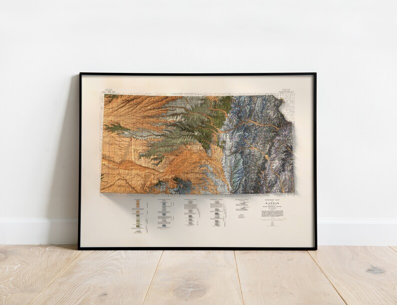Puede incluir: Un mapa vintage del estado de Kansas, impreso en tonos marrones, verdes y azules. El mapa est&aacute; enmarcado en un marco negro y est&aacute; colgado en una pared blanca.